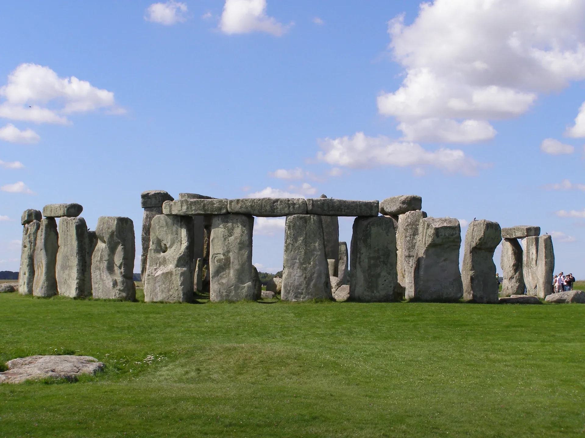 Aufrecht stehende Steine und Decksteine von Stonehenge unter einem wolkigen blauen Himmel.